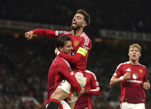 Manchester United's Mason Mount, left, celebrates with Bruno Fernandes after scoring their first goal of the game during the Europa League semifinal second leg soccer match between Manchester United and Athletic Bilbao in Manchester, Britain, Thursday, May 8, 2025. (Martin Rickett/PA via AP)